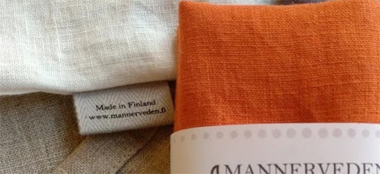 Kuvituskuva pellavaisista pyyheliinoista, näkyvillä osa Mannerveden ompelimon logosta.