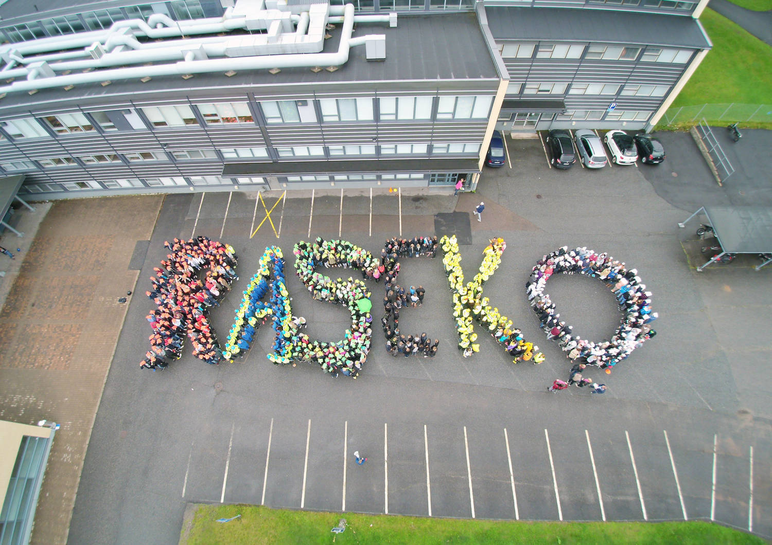 People are standing outside and constructing text of Raseko.