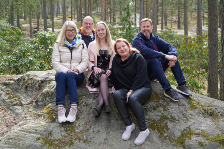 5 person are sitting on the stone.