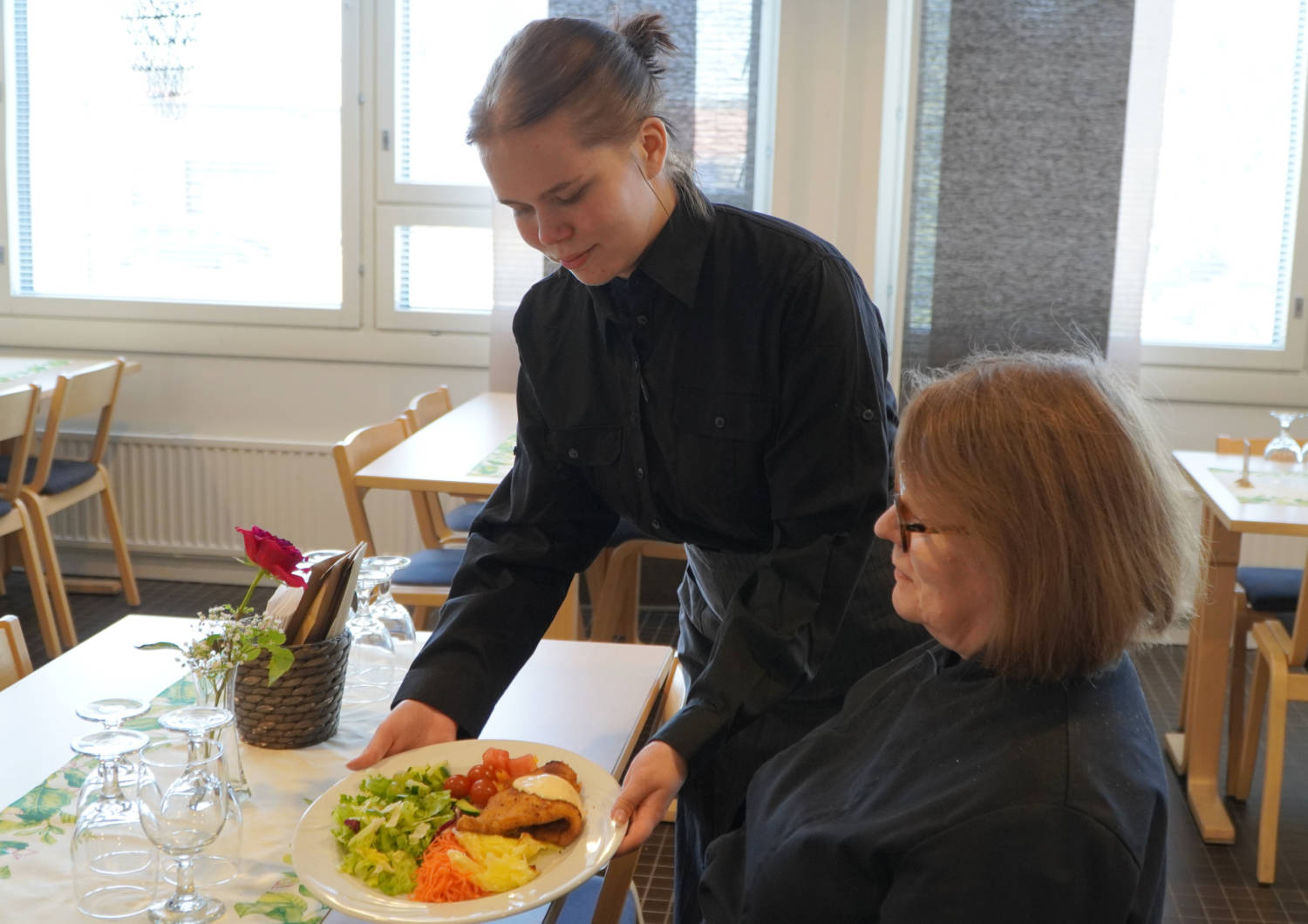 Henkilö tarjoilemassa ruokaa.