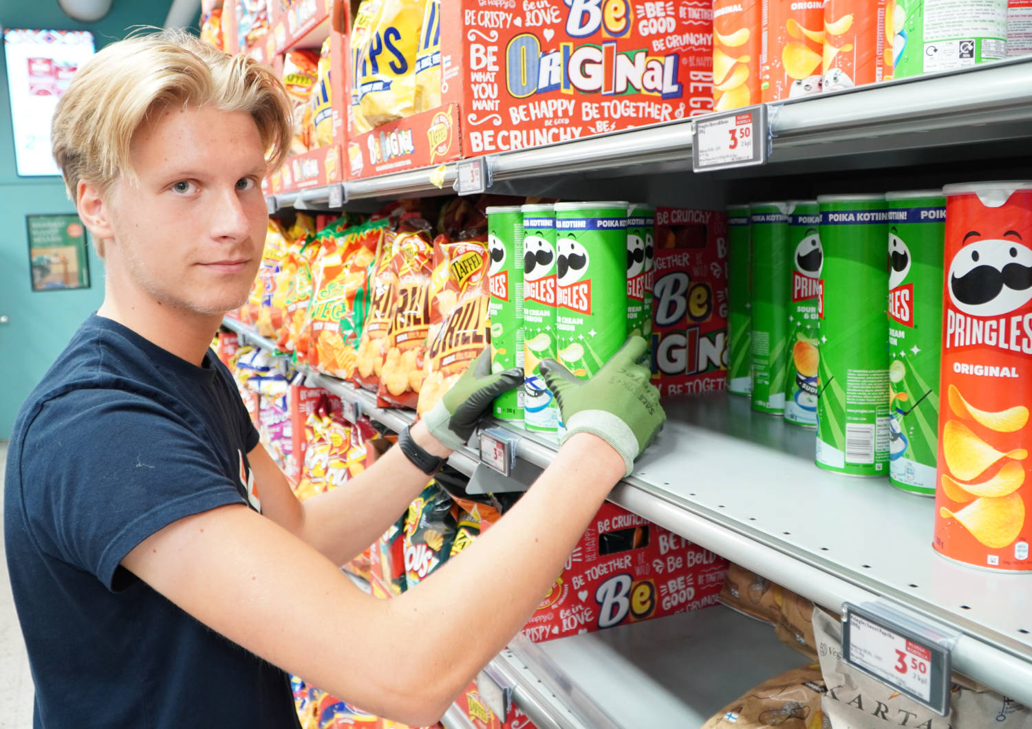 Henkilö työskentelemässä sipsiosastolla ruokakaupassa.