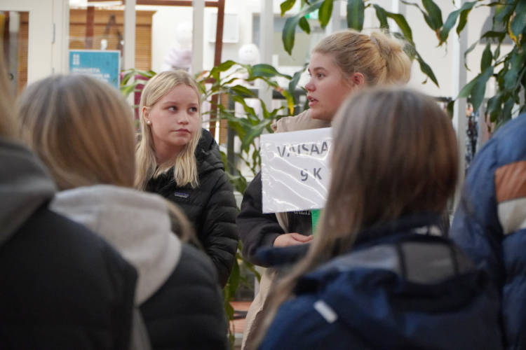 Kaksi henkilöä puhumassa muille ihmisille.