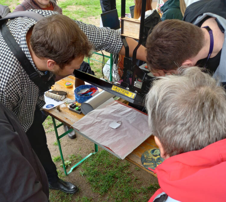 Three people examining the device.