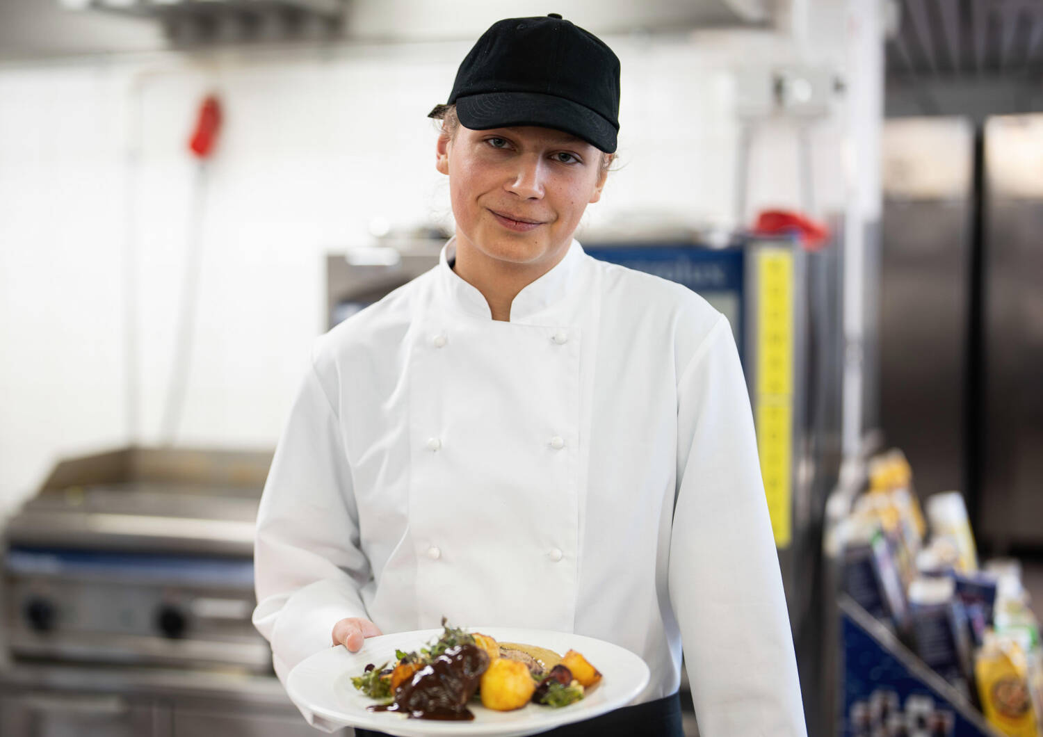 A person dressed as a chef holding a portion.