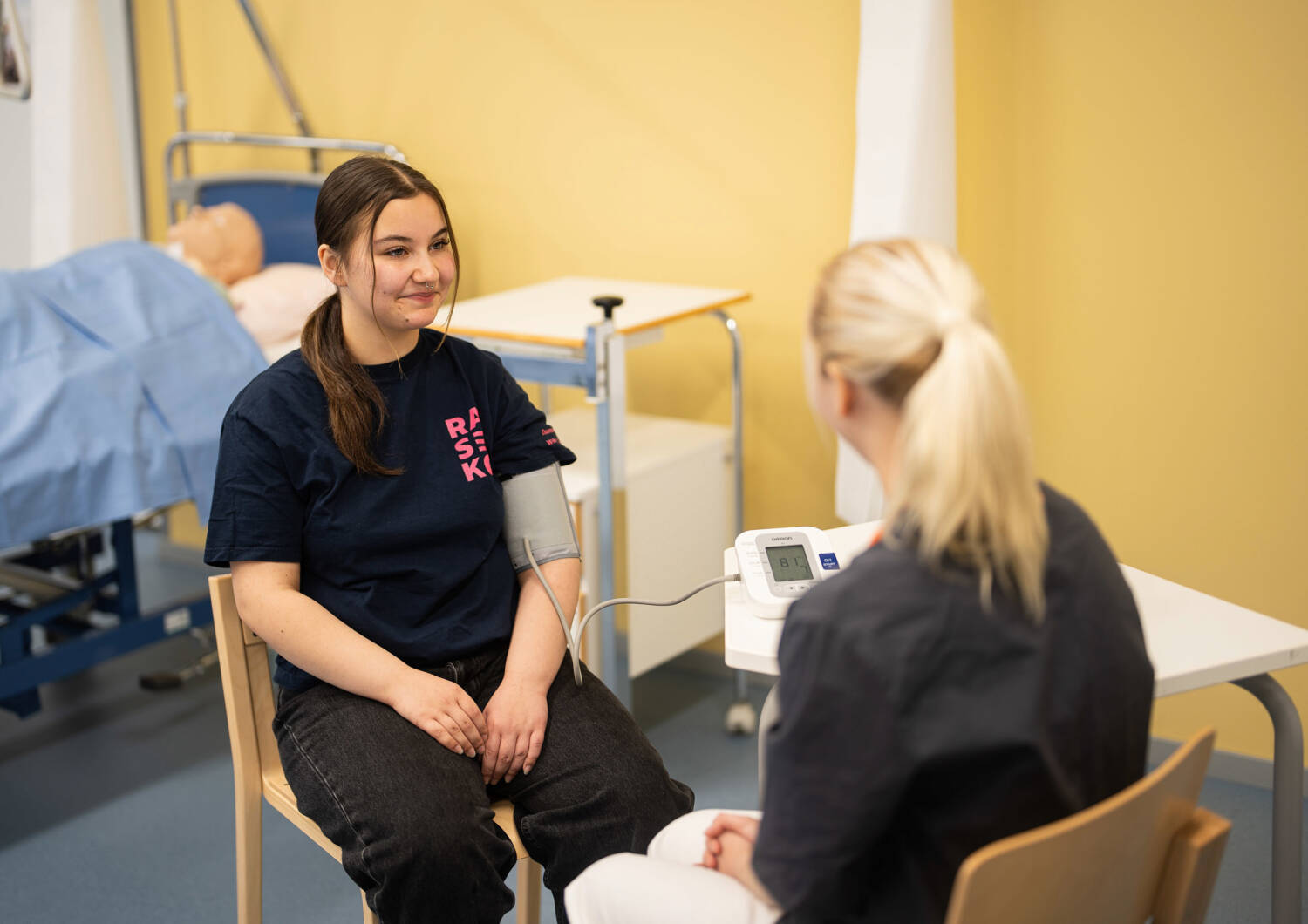 A person measures another person's blood pressure.