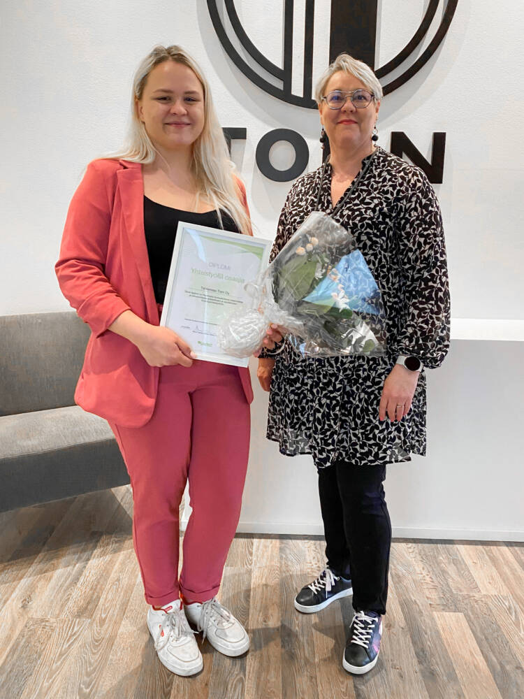 Sari Mömmö käsissään "Yhteistyöllä osaajia"-diplomi ja kukkakimppu sekä opettaja Mervi Mäkelä.