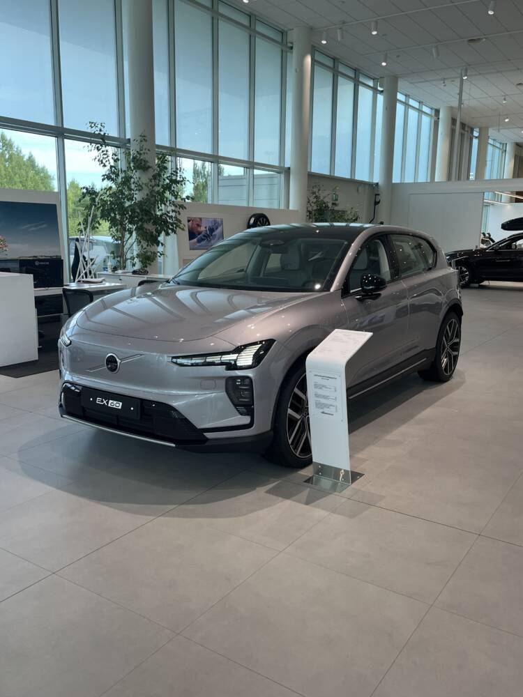 Harmaa auto esillä autokaupassa.